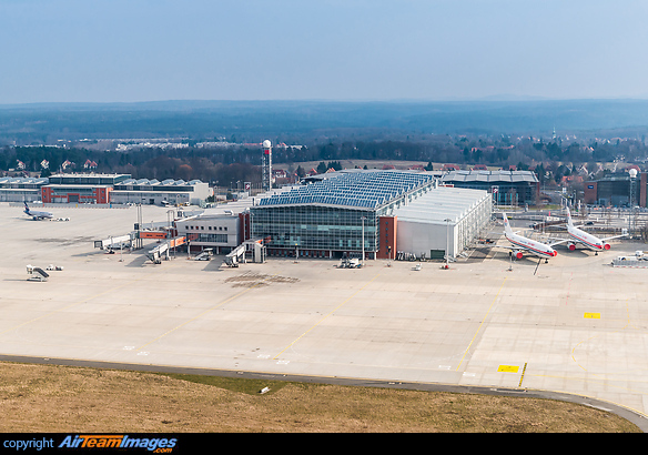 Dresden Airport terminal building with Aeroflot Superjet 100 being pushed back and two China Eastern Airbus A300-600s (B-2318 and B-2324) parked next to the terminal, waiting for conversion to freighters at Elbe Flugzeugwerke EFW. Dresden Airport