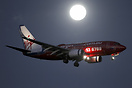 A Virgin Blue on approach to land at Melbourne with a beaming full moo...