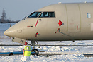 A snowman has been made by the airport staff in front of a parked CRJ ...