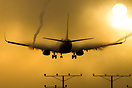 A Boeing 737 creating vapor trails and condensation while landing at L...