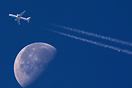 Contrail passing the moon