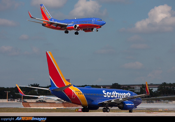 New livery Southwest aircraft awaits at the hold short line for old livery aircraft to land at Fort Launderdale. Boeing 737-7H4