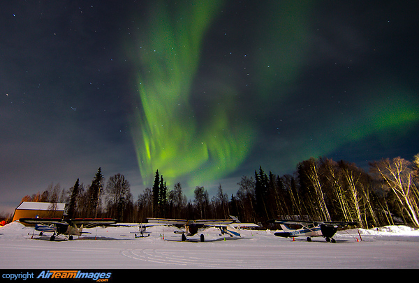 With all the aircraft parked for the night the light show provided by the Aurora Borealis blazes away in the night sky over Talkeetna airport in Alaska USA. Talkeetna Airport