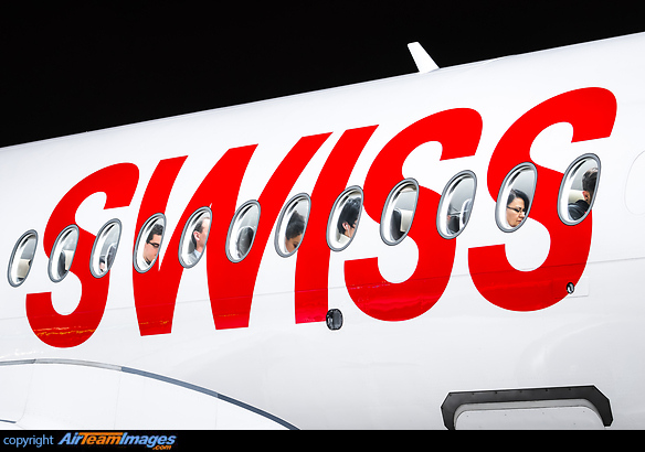 Swiss characters on the fuselage of the aircraft with passengers in their seats. Airbus A220-100