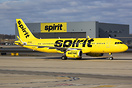 Spirit Airlines A320 taxies past hangar signage that matches its liver...