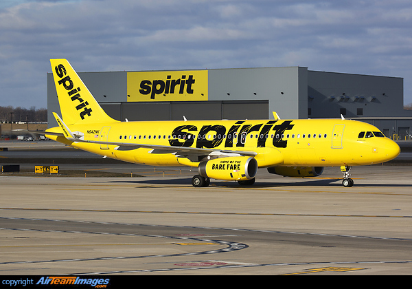 Spirit Airlines A320 taxies past hangar signage that matches its livery. Airbus A320-232