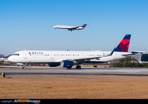 Speeding up on the runway with a Delta MD-80 on final approach in the background. Airbus A321-211