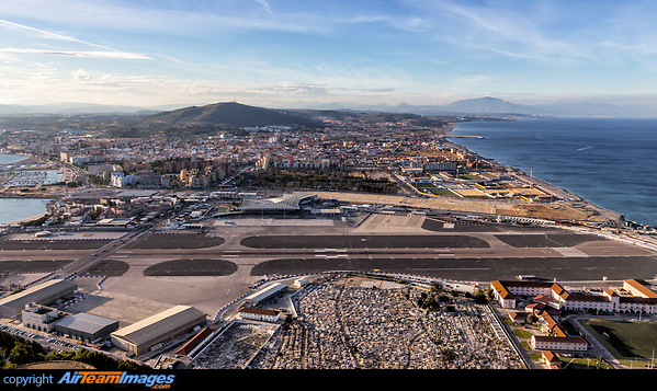 An overview of the runway and terminal in Gibraltar, along with the famous road which crosses the runway. Looking north towards the Spanish mainland. Gibraltar Airport