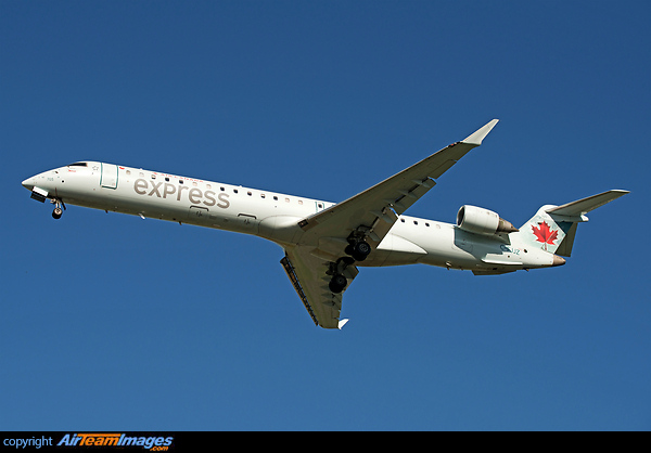 On final approach in golden light with the belly fully lit with warm sun rays Bombardier CRJ-705ER