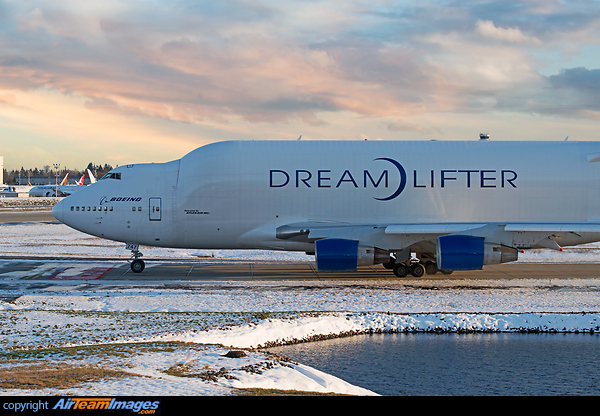 Taxing out in a snow covered airport with the warm golden setting sun in background Boeing 747-400LCF Dreamlifter