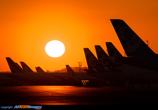 The Sun setting right it the middle of a bunch of aicraft under storage Paris Orly Airport