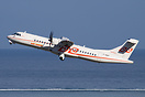 An Air Tahiti ATR72 taking off in front of the blue lagoon